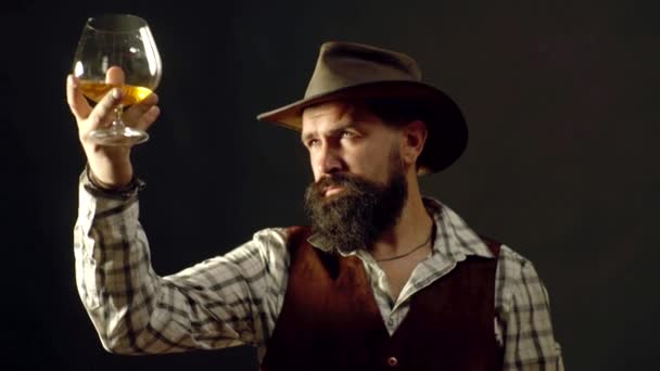 Der gutaussehende bärtige Geschäftsmann trinkt teuren Cognac. attraktiver Barkeeper in der Whiskey-Bar. stilvoller reicher Mann mit einem Glas alten Cognac. — Stockvideo