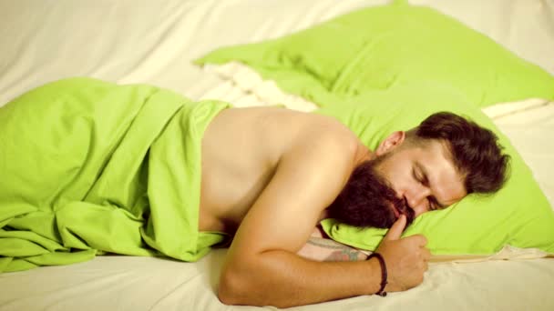 Momenti video divertenti. Un bell'uomo che dorme a letto. L'uomo dorme sul letto con un sonno molto profondo. Giovane a letto - cercando di dormire . — Video Stock