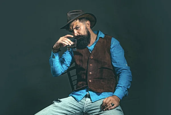 Elegante y elegante barbudo Barman sostiene vaso de whisky. Concepto de bebidas de lujo. El hombre a la moda en la camisa blanca y los tirantes. —  Fotos de Stock