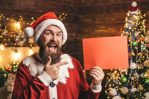 Grußkarte mit Kopie cpase. Frohe Winterzeit. Weihnachtsmann Winter Porträt. Modeporträt eines gutaussehenden Mannes im Haus mit Weihnachtsbaum. — Stockfoto