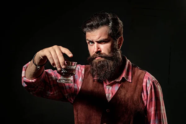 Eleganter und stilvoller Mann in klassischer Kleidung mit Glas und Whiskey in der Hand. — Stockfoto