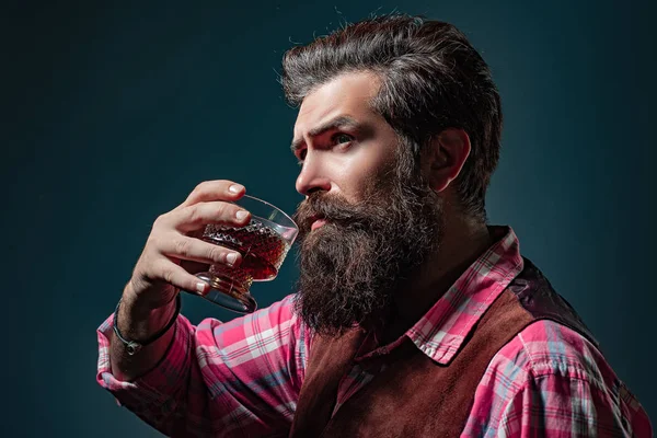 Homem Barman com barba segura conhaque de vidro. Sommelier saboreia bebida alcoólica cara. — Fotografia de Stock