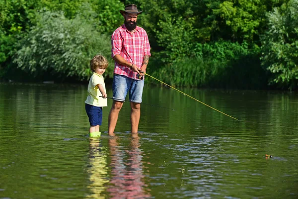 Portrait of two generation men fishing. Concept of a retirement age. Little helper fishing. Happy father and son fishing with fishing rods. Generations men.