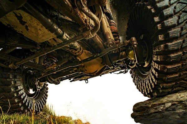 Concepto de neumáticos de coche fuera de la carretera. Amortiguador. Coche todoterreno en mal camino. Carrera de SUV en tierra. Vehículo todoterreno saliendo de un agujero de barro . — Foto de Stock