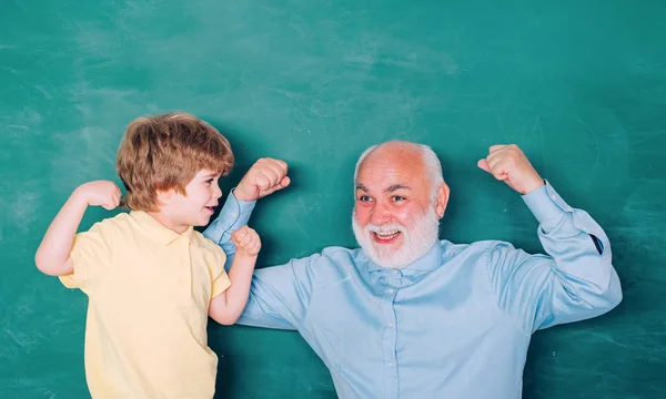 교사는 교육 수업에 자신의 십대 학생을 돕는. 교육과 교육의 개념. 자신감 있는 늙은 남자 교사의 초상화입니다. 칠판 배경을 통해 행복한 학생. — 스톡 사진