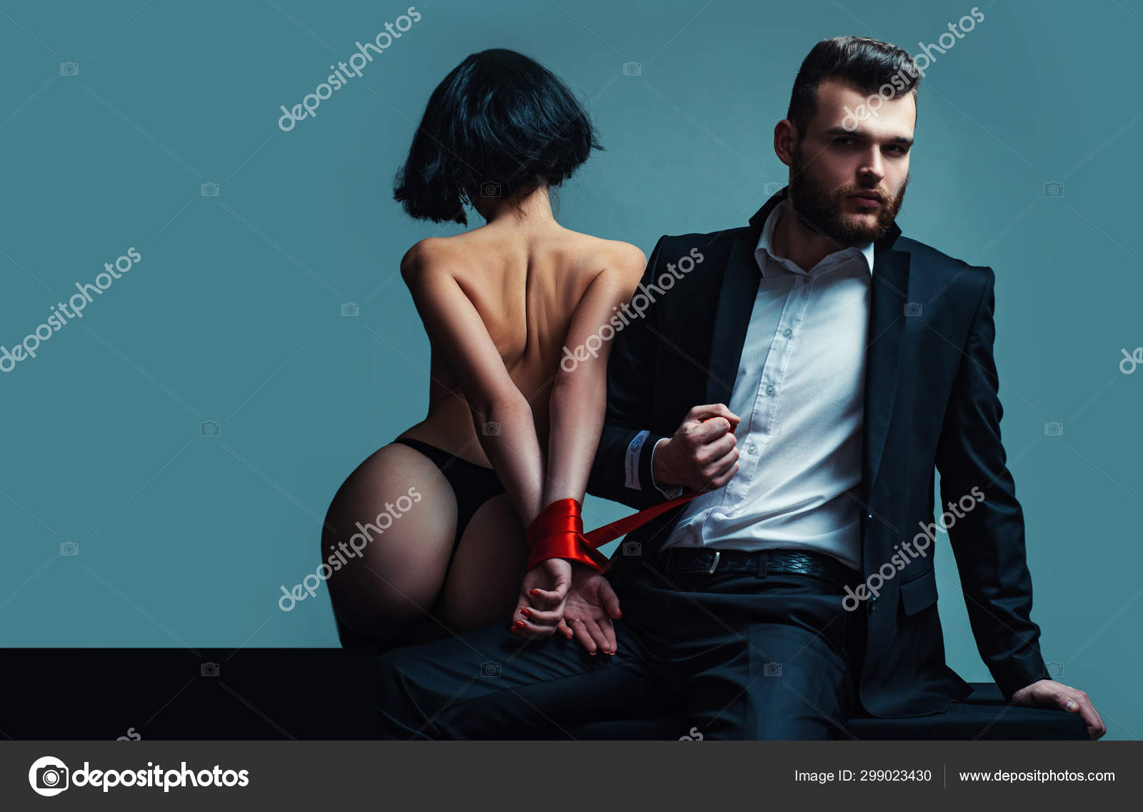 Tease and seduce. Passionate lovers. Sex domination. Sex submission. Macho well groomed hipster and naked sexy woman tied hands red ribbon pic