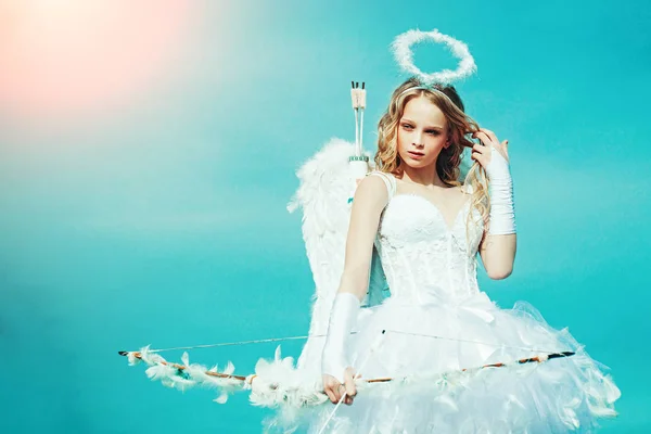 Bonita niña blanca como el Cupido con un arco y flecha felicitando el día de San Valentín. Chica querubín —  Fotos de Stock