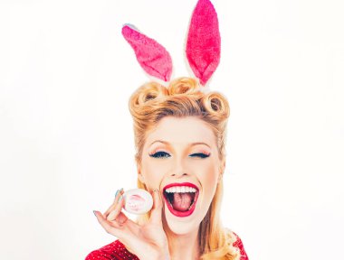 Paskalya Bayramı. Tavşan kulaklı seksi kadın göz kırpıyor. Paskalya bayramını tavşan kulaklı tatlı kız kutluyor. İzole edilmiş beyaz arka plan. Paskalya tavşanı kulaklı bir kadın ve çok şehvetli görünüyor..