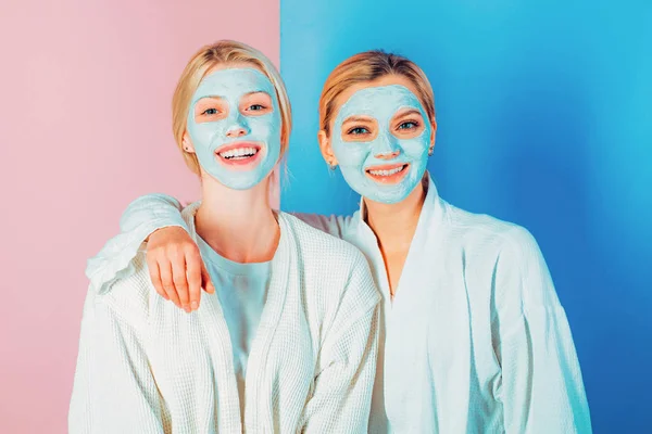 Hermanas o mamá e hija escalofriantes haciendo mascarilla facial de barro. Máscara anti edad. Mantente hermosa. Cuidado de la piel para todas las edades. Mujeres chicas bastante sonrientes con máscara de arcilla — Foto de Stock