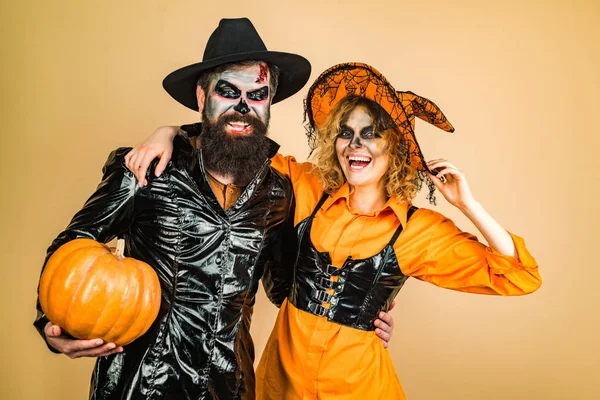 Halloween sorpreso donna e bell'uomo barbuto in cappello di Halloween e costume tenendo zucca . — Foto Stock