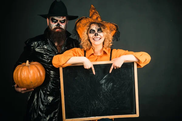 Una coppia di Halloween. Due giovani donne emotive e l'uomo in costumi di Halloween sulla festa di Halloween con zucca. Dolcetto o scherzetto . — Foto Stock