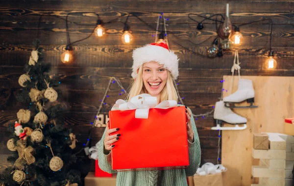 Belle femme avec cadeau de boîte de Noël à la maison. Fille modèle de beauté à Santa Hat sur décoration design à la maison. Amical et joyeux. Des gens heureux . — Photo