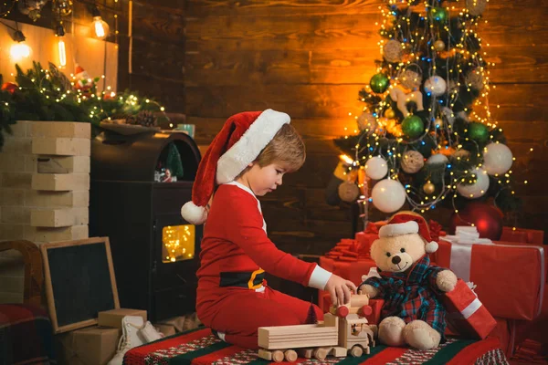 Frohe und strahlende Weihnachten. schönes Baby genieße Weihnachten. Familienurlaub. Kindheitserinnerungen. Weihnachtsmann kleines Kind feiern Weihnachten zu Hause. Junge Kind spielen in der Nähe von Weihnachtsbaum. Countdown zum neuen Jahr — Stockfoto