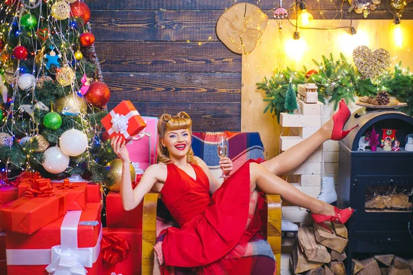Schoonheid kerst mode model meisje houden Xmas Gift Box. Gelukkige vrouw met kerstcadeau over Kerstmis interieur achtergrond. — Stockfoto