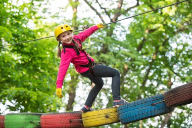 Küçük çocuk kask ve güvenlik ekipmanları ile macera aktivite parkı tırmanma. Kask - Çocuk oynamak için güvenlik ekipmanları. Ağaçlara tırmanan mutlu çocuk.