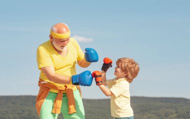 Boks eldivenleri ile sağlıklı savaşçı büyükbaba ve torunu. Büyükbaba ve torunu sabah boks eğitimi yapıyor. Boks.