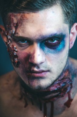Zombi makyajlı bir adamın yakın çekim portresi. Korku ile Korkunç yüz adam Balkabağı baş jack fener tutarak makyaj. Cadılar Bayramı yüz sanatı. Yarım yüz portresi. Korkunç ve kanlı kaslı zombi adam.