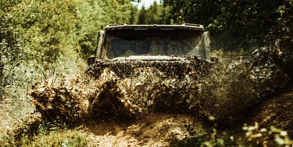 Yol spor kamyondan dağlar manzara arasında. Offroad araç bir çamur delik tehlikesi dışarı geliyor. Drag racing araba lastik yakar. Aşırı. Jeep bir su birikintisi içine çöktü ve kir bir sprey kadar aldı.