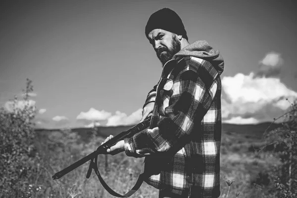 Chasseur d'hommes. Période de chasse. Un homme armé. Un chasseur avec un fusil de chasse et une forme de chasse pour chasser dans une forêt d'automne. L'homme est à la chasse . — Photo