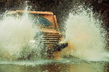Off-road aracı dağda gider. Lastik yarış için hazırlık. Sefer offroader. Jeep açık havada macera. Mudding off-Road'a benziyor ıslak çamur veya kil yüzölçümü ile.