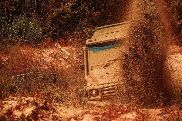 越野运动卡车之间的山脉景观。泥巴是在潮湿的泥或粘土的区域中滑行。泥巴和水花在公路上疾驰而去。四轮驱动徒步旅行. — 图库照片