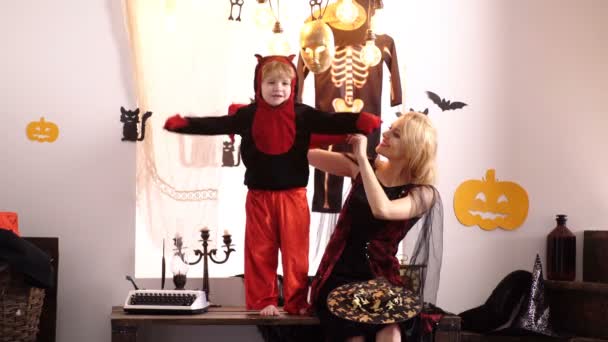 Maman et son fils jouent pour Halloween sorcières costume à la maison. Mère et enfant jouent ensemble. 31 octobre. Chapeau magique. Meilleures idées pour Halloween. Mère portant comme sorcière, fils portant comme diable . — Video