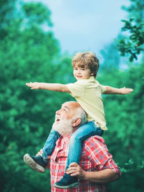 Büyükbabam torunuyla konuşuyor. Küçük çocuk ve dedesi gün batımı gökyüzü üzerinde yaşam ve doğanın tadını çıkaran el kaldırarak. Baba ve çocuk gülümseyen ve sarılma.