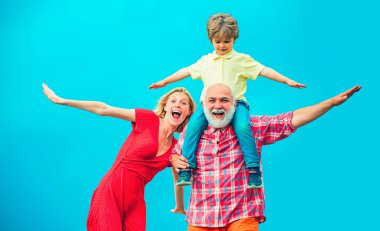 Aile kuşağı ve ilişkiler kavramı. Arkadaş canlısı aile kavramı. Büyükbabam ve küçük torunum ve annem mavi gökyüzünde oynuyorlar..