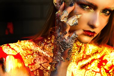 Altın parlak ışıltılar Yüksek Moda Halloween model kadın. Cadılar Bayramı tasarımı makyaj. Metalik bakışta Moda sanat portresi. Cadılar Bayramı Moda sanat Altın deri Kadın yüz portre yakın çekim.