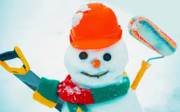 Scène hivernale avec bonhomme de neige bâtisseur sur fond de neige blanche. Fabricant de bonhomme de neige fait à la main dans la neige en plein air. Carte de voeux d'art d'hiver pour les constructeurs . — Photo