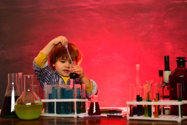 Little kids scientist earning chemistry in school lab. Science. Happy little scientist making experiment with test tube. schoolchild