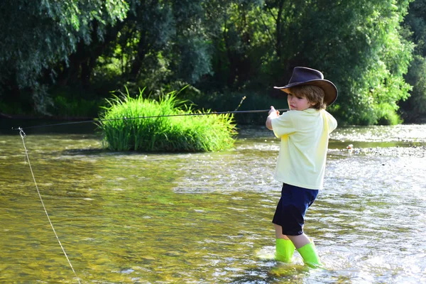Pequeno pescador pronto para ir pescar. Jovem pesca com mosca. Rapaz bonito pescar na lagoa. Criança aprendendo a pescar segurando uma vara em um rio . — Fotografia de Stock