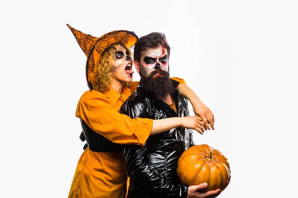 Belleza chica de Halloween y hombre barbudo guapo sostienen la calabaza sobre un fondo aislado. Fiesta de Halloween gente . — Foto de Stock