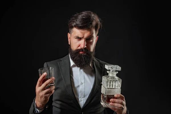 Koncepcja napojów luksusowych. Popijając whiskey. Man BarTender trzyma szklankę whisky. Brodaty przystojny mężczyzna trzyma szklankę whisky. — Zdjęcie stockowe