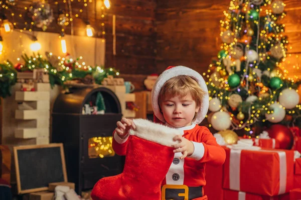 Feliz día. concepto de medias de Navidad. Niño cara alegre consiguió regalo en calcetín de Navidad. Contenido de la media navideña. Alegría y felicidad. Momentos de infancia. Niño niño santa celebrar regalo de Navidad — Foto de Stock