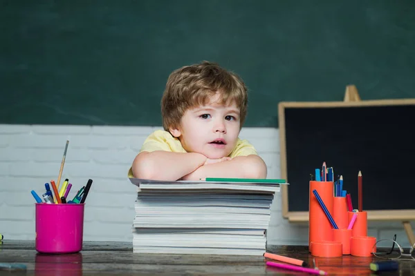 Ragazzino divertente che punta sulla lavagna - concetto scolastico. Allegro sorridente bambino Pupillo divertirsi contro lavagna. Processo educativo. Scuola per bambini . — Foto Stock