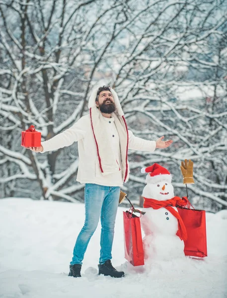 Frohe Weihnachten und ein gutes neues Jahr. Styling Weihnachtsmann Hipster mit langem Bart posiert auf dem weihnachtlichen Schnee Hintergrund. — Stockfoto