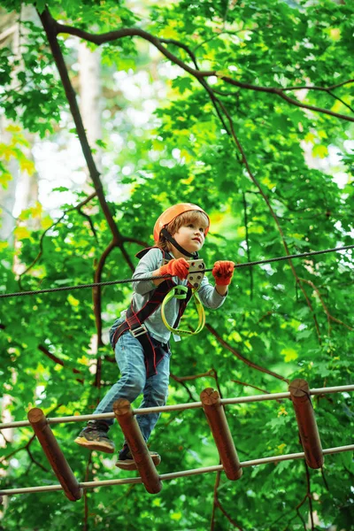 Vai à Aventura Macaco. Criança alpinista em treino. Criança subindo no parque de corda alta. Crianças divertidas. Rede de carga de escalada e pendurado log. Crianças activas. Parque de estacionamento — Fotografia de Stock