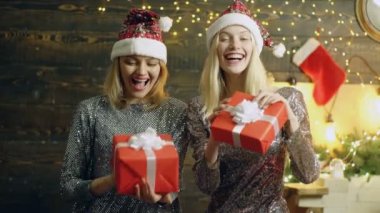Noel hediyeleri olan güzel kızlar. Noel hediye kutusu ve kadınların mutlu yüzleri. Xmas anları. Heyecanlı kadın. Yeni yıl partisini kutluyoruz. Kırmızı hediye kutuları ile iki gülümseyen muhteşem kadın. Mutlu Noeller.
