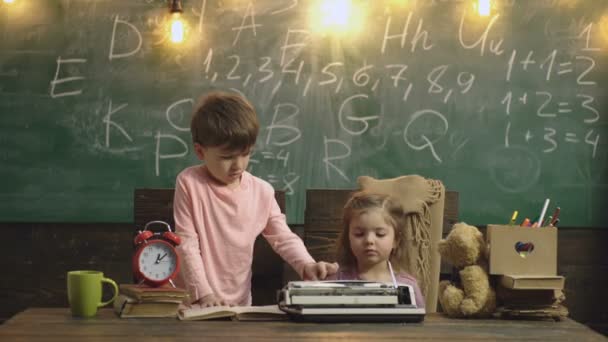 Óvodáskorú fiú és a lány a tanulás típus az írógép az iskolai osztályban a zöld iskolai fórumon háttérben. Oktatás, általános iskola, tanulás és az emberek koncepcióját. Vissza az iskolába. Óvodai — Stock videók