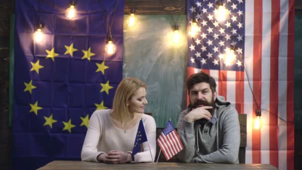 L'homme et la femme communiquent sur le fond des drapeaux de l'UE et de l'Amérique. Drapeaux de l'UE et de l'Amérique fond. Concept de coopération États-Unis-UE. Concept de diplomatie. Union européenne et Amérique . — Video