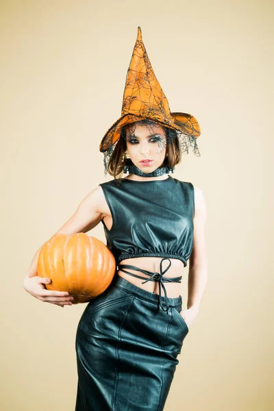 Festa di Halloween ragazza. Cappello da strega. Felice strega di Halloween con la zucca. Giovane donna con cappello da strega vestita da vampiro per la festa di Halloween . — Foto Stock