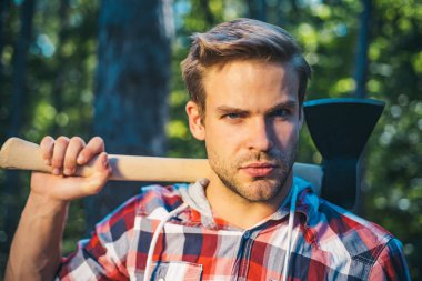 Elinde baltayla oduncu. Ormanın yakınında baltası olan yakışıklı bir genç. Odun yenilenebilir enerji kaynağı olarak kullanılıyor. Adam işini yapıyor. Sıkı çalışmadan sonra dinlenmek.