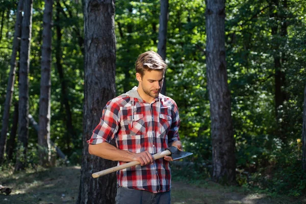 Houthakker met bijl op bosachtergrond. Ontbossing is een belangrijke oorzaak van landdegradatie en destabilisatie van natuurlijke ecosystemen. — Stockfoto