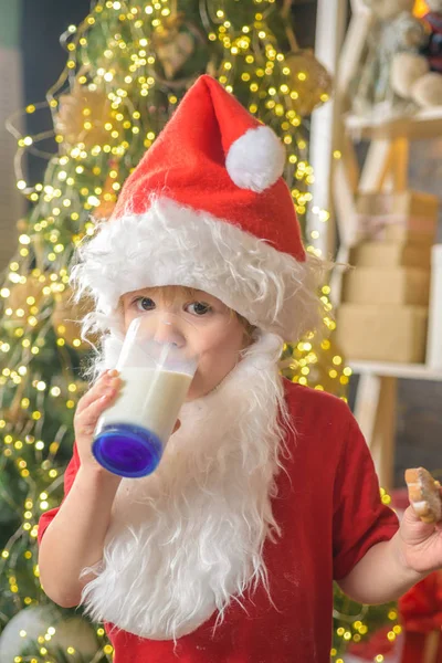 Święty Mikołaj je ciasteczka i pije mleko w Wigilię. Szczęśliwego Świętego Mikołaja jedzącego ciasteczka i pijącego mleko w domu. Cookies dla dziecka Świętego Mikołaja. — Zdjęcie stockowe
