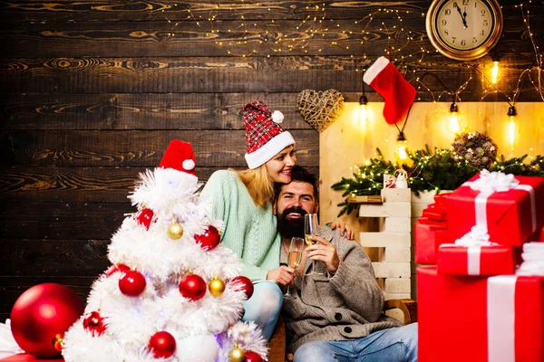 夫妇庆祝新年。冬天的人戴着红色的圣诞老人帽子。圣诞树在家里装饰。新年快乐。圣诞快乐夫妇. — 图库照片