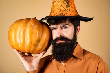 Kabak ile Halloween adam - Tatil kutlama kavramı. Sakallı adam Cadılar Bayramı şapkalı balkabağı yla yemek pişirir. Hediye ver yoksa karışmam. Cadılar Bayramı şapka sakallı korkunç hipster adam.