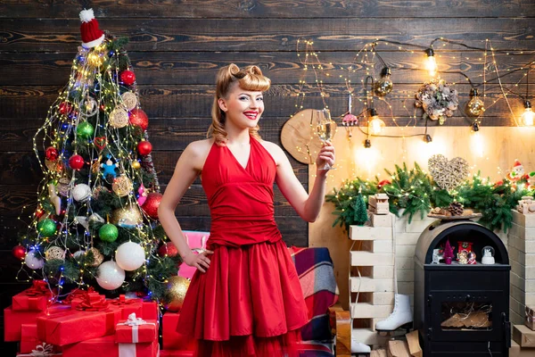 Mooie blonde meisje in avondjurk glimlachen en het houden van glas Champagne. Mooi meisje dragen in rode kerst jurk. Mooi Nieuwjaar en kerst scène. — Stockfoto