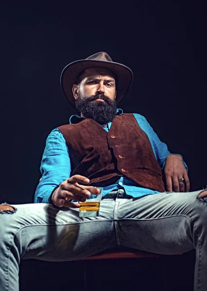 Homme d'affaires barbu en costume élégant avec un verre de whisky. Concept de style mode. L'homme barbu joyeux boit du whisky cher . — Photo