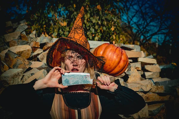 Holiday Halloween carnival costume. Halloween party art design. Beautiful young surprised woman in witch hat costume and holding Witch broom.